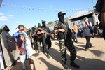 Fighters from Ezzedine al-Qassam Brigades, the armed wing of the Hamas movement, walk through Gaza City streets to visit released Palestinian prisoners in their homes on October 19, 2011, as Gaza's ruling movement announced it would give $2,000 to each prisoner freed by Israel to the coastal territory under a landmark prisoner exchange deal. Photo by Ahmed Deeb/WN