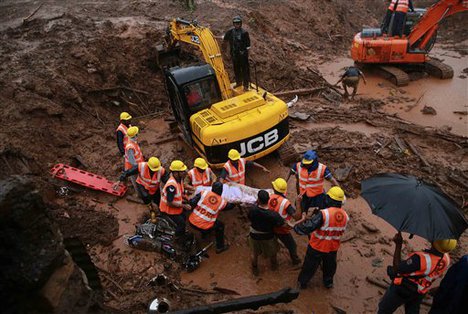 Rescue workers carry the body of a victim after a massive landslide in Malin village in Pune district of western Maharashtra state, India, Thursday, July 31, 2014.