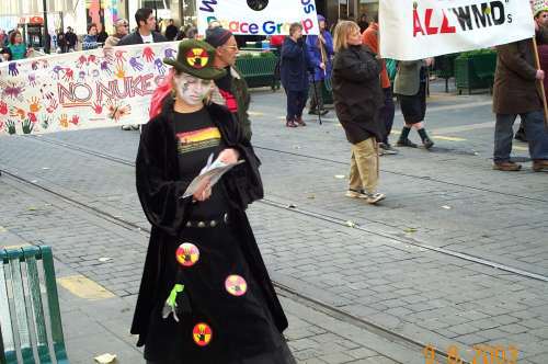 Woman in black with anti-nuclear patches and whitened face