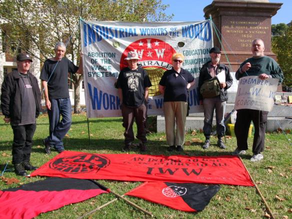 Lineup in front of IWW banner next to 8-hours monument