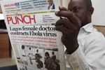 A man reads a local newspaper with headline news about a Lagos female doctor contracts Ebola Virus, in Lagos, Nigeria, Tuesday, Aug. 5, 2014.