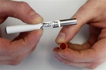 shows Blair Roberts, a 22-year-old sales associate at Colorado E-Smokes as he holds an electronic cigarette and the filter end that holds the liquid nicotine solution at an E-Smokes store in Aurora, Colo. There’s no legal age minimum for e-cigarettes in Colorado, and growing health concern that so-called “vaping” of nicotine is growing among kids has made Colorado the latest state to consider age requirements for the nicotine devices popping up at mall kiosks and convenience stores