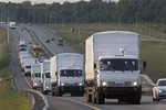 A convoy of white trucks carrying humanitarian aid passes along the main road M4 (Don highway) Voronezh region, Russia, Tuesday, Aug. 12, 2014.