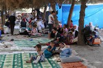 Displaced Iraqis from the Yazidi community gather at a park near the Turkey-Iraq border at the Ibrahim al-Khalil crossing, as they try to cross to Turkey, in Zakho, 300 miles (475 kilometers) northwest of Baghdad, Iraq, Friday, Aug. 15, 2014.