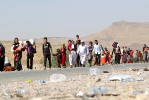 Displaced Iraqi families from the Yazidi community cross the Iraqi-Syrian border, 13 August. Photo: Getty