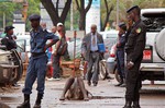 Guinea Police secure the area around a man who collapsed in a puddle of water on the street, and people would not approach him as they fear he may be suffering from the Ebola virus in the city of Conakry, Guinea, Wednesday, Aug. 6, 2014.