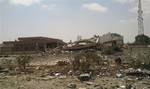 A man stands on the rubble of the main building of the security headquarters that was collapsed after an attack by Islamic hard-line militias in Benghazi, Libya, Friday, Aug. 1, 2014. I