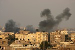 Smoke billows following an Israeli air strike in the Rafah refugee camp in southern Gaza Strip on November 18, 2012. Israeli war planes hit a Gaza City media center and homes in northern Gaza in the early morning, as the death toll mounted, despite suggestions from Egypt's President Mohamed Morsi that there could be a "ceasefire soon."Photo by Ahmad Deeb / WN