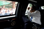 File - President Barack Obama waves to people along the motorcade route while traveling from the University of Indonesia to the airport in Jakarta, Indonesia, Nov. 10, 2010.