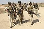 Iraqi security forces and Iraqi Shi'ite volunteers carry their weapons during an intensive security deployment to fight against militants of the Islamic State.