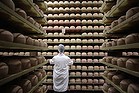 A cheesemonger checks mimolette cheese at a production site in France.