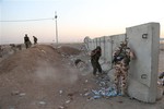 File - Kurdish Peshmerga fighters take cover during airstrikes targeting Islamic State militants near the Khazer checkpoint outside of the city of Irbil in northern Iraq, Friday, Aug. 8, 2014.