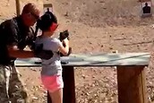 Shooting instructor Charles Vacca stands next to a 9-year-old girl at the Last Stop shooting range in White Hills, Arizona near the Nevada border, on August 25, 2014, in this still image taken from video courtesy of the Mohave County Sheriff's Office. The girl accidentally shot and killed her shooting instructor with an Israeli-made Uzi submachine gun when the weapon's strong recoil caused her to lose control of her aim, police said on Tuesday. REUTERS/Mohave County Sheriff's Office/Handout via Reuters  (UNITED STATES - Tags: SOCIETY) NO SALES. NO ARCHIVES. FOR EDITORIAL USE ONLY. NOT FOR SALE FOR MARKETING OR ADVERTISING CAMPAIGNS. THIS IMAGE HAS BEEN SUPPLIED BY A THIRD PARTY. IT IS DISTRIBUTED, EXACTLY AS RECEIVED BY REUTERS, AS A SERVICE TO CLIENTS