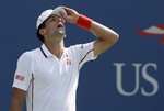 Novak Djokovic, of Serbia, adjusts his cap between points against Kei Nishikori