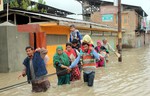 Kashmiri residents wade through floodwaters as they head for higher ground in the outskirts of Srinagar, India, Saturday on September 06, 2014.