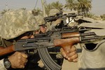 File - U.S. Army Soldier from the 1st Stryker Brigade Combat Team return fire on insurgents from a rooftop in Buhriz, Iraq, March 14, 2007.