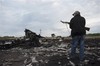 File - A pro-Russia fighter stands on guard at the crash site of a Malaysia Airlines jet near the village of Hrabove, eastern Ukraine, Saturday, July 19, 2014.