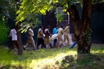 Workers carry the body of a man who was killed by a white tiger past its cage at the zoo in New Delhi, India, Tuesday, Sept. 23, 2014.