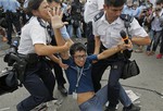 A pro-democracy protester is taken away by police officers as an ambulance tries to leave the compound of the chief executive office in Hong Kong, Friday, Oct. 3, 2014.