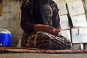 In this photo taken Wednesday, Oct. 8, 2014, a 15-year-old Yazidi girl captured by the Islamic State group and forcibly married to a militant in Syria sits on the floor of a one-room house she now shares with her family after escaping in early August, while speaking in an interview with The Associated Press in Maqluba, a hamlet near the Kurdish city of Dahuk, 260 miles (430 kilometers) northwest of Baghdad, Iraq. The girl was among hundreds of women and girls from the Yazidi religious minority captured by Islamic State fighters in early August when the militants overran their hometown of Sinjar in northwestern Iraq.