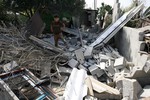 A Palestinians inspect the site of an Israeli air strike in Khan Yunis in the southern Gaza Strip on July 6, 2014. Israeli aircraft attacked 10 sites used by Palestinian militants in the Gaza Strip on Sunday in response to persistent rocket strikes from the enclave, the Israeli military said. Photo by Ahmed Deeb / WN