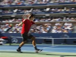 In a photo made using a slow shutter speed to create a blurred effect, Roger Federer of Switzerland returns a shot to Novak Djokovic of Serbia during a semifinal match at the U.S. Open tennis tournament in New York, Saturday, Sept. 10, 2011.