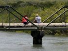 A couple fishing off Harbour Road during the king tide that hit on Saturday. Photo Lauren Reed / Daily Mercury