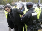 Philosopher Cornel West, center, is taken into custody after performing an act of civil disobedience at the Ferguson, Mo., police station Monday, Oct. 13, 2014, as hundreds continue to protest the fatal shooting of 18-year-old Michael Brown by police in August.