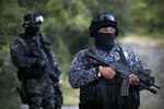 Mexican navy marines and officers belonging to the Attorney General's Office, guard the area where new clandestine mass graves were found near the town of La Joya, on the outskirts of Iguala, Mexico, Thursday, Oct. 9, 2014.