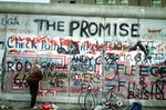 File - A West German woman attempts to chip off a piece of the Berlin Wall as a souvenir, 14 Nov 1989.