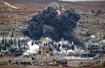 Smoke rises from the Syrian city of Kobani, following an airstrike by the US led coalition, seen from a hilltop outside Suruc, on the Turkey-Syria border Monday, Nov. 17, 2014.