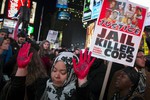 In this Nov. 25, 2014 file photo, demonstrator Maryam Said raises her painted hands during a protest against a grand jury's decision on Monday not to indict Ferguson police officer Darren Wilson in the shooting of Michael Brown in New York.