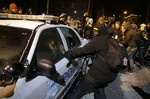 Protesters vandalize a police vehicle near Ferguson City Hall Tuesday, Nov. 25, 2014, in Ferguson, Missouri, following a grand jury's decision not to indict police officer Darren Wilson in the fatal shooting of Michael Brown.