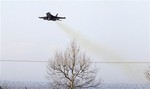 An F-18 jet fighter flies over the Nato airbase in Aviano, Italy, Sunday, March 20, 2011