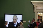 Press watch Russian President Vladimir Putin during his annual state of the nation address in the Kremlin in Moscow, Russia, on Thursday, Dec. 4, 2014.