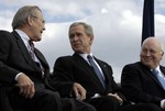 File - Secretary of Defense Donald Rumsfeld shares a laugh with President George W. Bush and Vice President Dick Cheney during his farewell parade at the Pentagon.