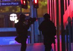 Armed tactical response officers enter the building after shots were fired during a cafe siege in the central business district of Sydney , Australia, Tuesday, Dec. 16, 2014.