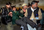 Pakistani volunteers carry a student injured in the shootout at a school under attack by Taliban gunmen, at a local hospital in Peshawar, Pakistan,Tuesday, Dec. 16, 2014.