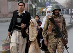 Pakistani parents escort their children outside a school attacked by the Taliban in Peshawar, Pakistan, Tuesday, Dec. 16, 2014.