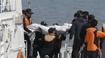 The body of a passenger aboard the Sewol ferry which sank in the water off the southern coast, is carried by rescue workers upon its arrival at a port in Jindo, south of Seoul, South Korea, Sunday, April 20, 2014.