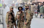 Pakistan army soldiers cordon off the area outside a school attacked by the Taliban in Peshawar, Pakistan, Tuesday, Dec. 16, 2014.