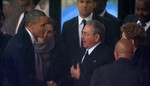 In this Dec. 10, 2013 file image from TV, U.S. President Barack Obama shakes hands with Cuban President Raul Castro at the FNB Stadium in Soweto, South Africa, in the rain for a memorial service for former South African President Nelson Mandela.