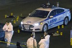 Bulletproof vests lie on each side of an NYPD patrol car as investigators work at the scene where two NYPD officers were shot in the Bedford-Stuyvesant neighborhood of the Brooklyn borough of New York on Saturday, Dec. 20, 2014.