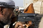 File - In this Wednesday, Nov. 19, 2014 photo, fighters from the Free Syrian Army, left, and the Kurdish People's Protection Units (YPG), center, join forces to fight Islamic State group militants in Kobani, Syria.