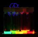 Colloidal quantum dots irradiated with a UV light. Different sized quantum dots emit different color light due to quantum confinement.