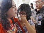 A relative of AirAsia flight QZ8501 passengers weeps as she waits for the latest news on the missing jetliner at Juanda International Airport in Surabaya, East Java, Indonesia, Sunday, Dec. 28, 2014.