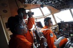 Crew of Indonesian Air Force C-130 airplane of the 31st Air Squadron scan the horizon during a search operation for the missing AirAsia flight 8501 jetliner over the waters of Karimata Strait in Indonesia, Monday, Dec. 29, 2014.