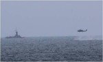 An MH-60R Sea Hawk helicopter attached to the guided-missile destroyer USS Sampson approaches an Indonesian navy patrol vessel in the Java Sea while searching for debris during the Indonesian-led search and recovery operations for AirAsia flight QZ8501, 31 December, 2014.