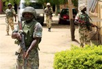 In this Thursday, June 6, 2013 file photo Nigerian soldiers stand guard at the offices of the state-run Nigerian Television Authority in Maiduguri, Nigeria.