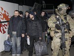 File - A Ukrainian soldier leads pro-Russian separatists during an exchange of prisoners outside Donetsk in eastern Ukraine, Friday Dec. 26, 2014.